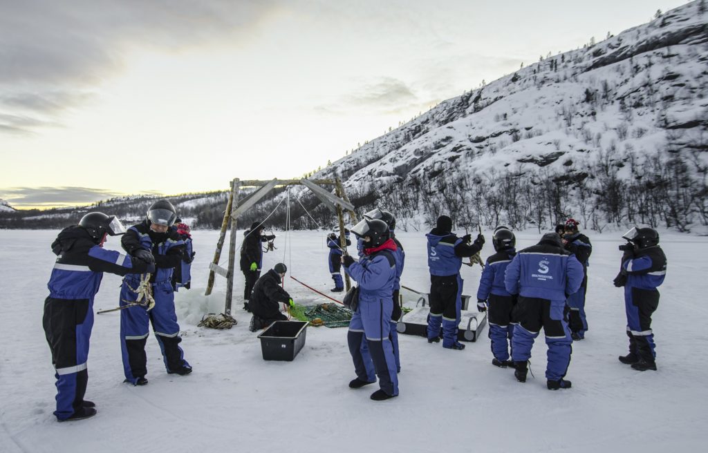 Guests King Crab ice fishing in their Norway Arctic Suits